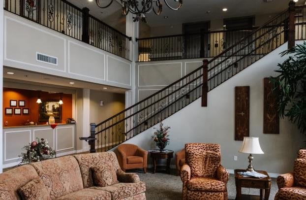 A cozy living room featuring a staircase, plush seating, and elegant decor.