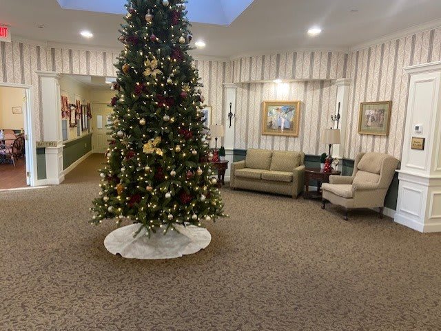 A beautifully decorated Christmas tree in a cozy lobby area.