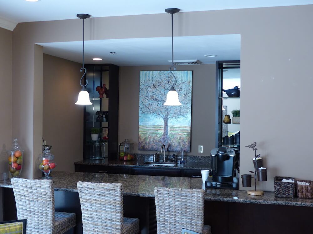 A modern kitchen space featuring a stylish counter with bar stools and pendant lighting.