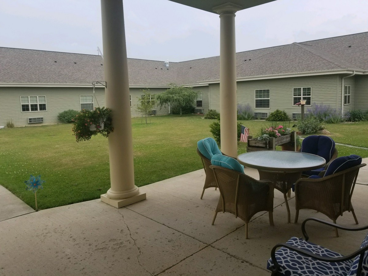 A cozy patio with outdoor seating overlooking a well-maintained garden.