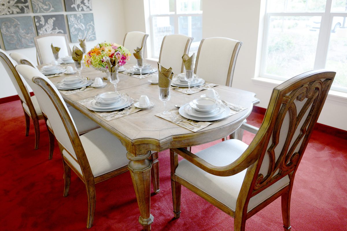 Elegant dining room with a set table and floral centerpiece.