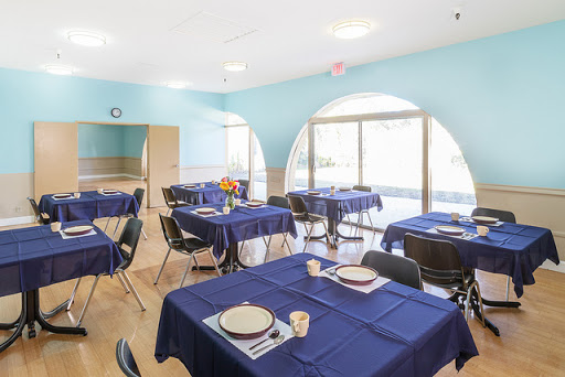 A beautifully arranged dining area with blue tablecloths and a spacious atmosphere.