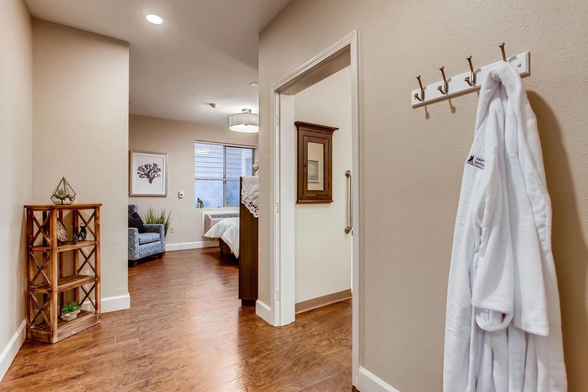 A cozy and inviting bedroom view from the hallway, featuring elegant home decor and wooden flooring.