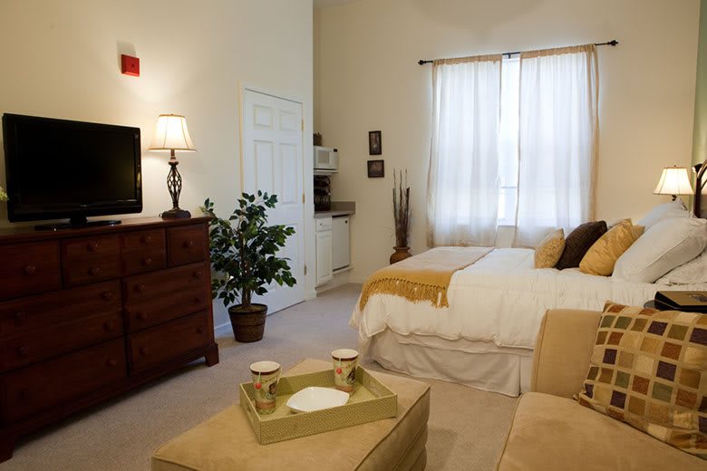 A cozy bedroom featuring a comfortable bed, modern decor, and warm lighting.