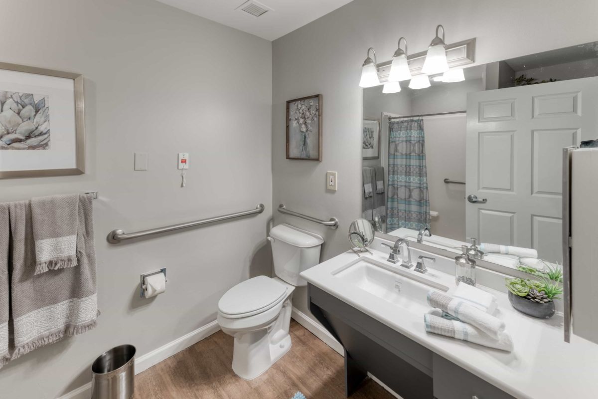 A modern bathroom with a sink, toilet, and shower area.