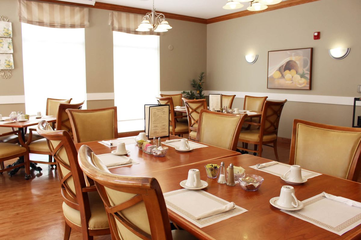 A cozy dining room with neatly set tables and comfortable chairs.