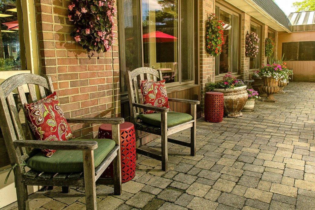 A cozy patio with comfortable chairs and decorative potted plants.