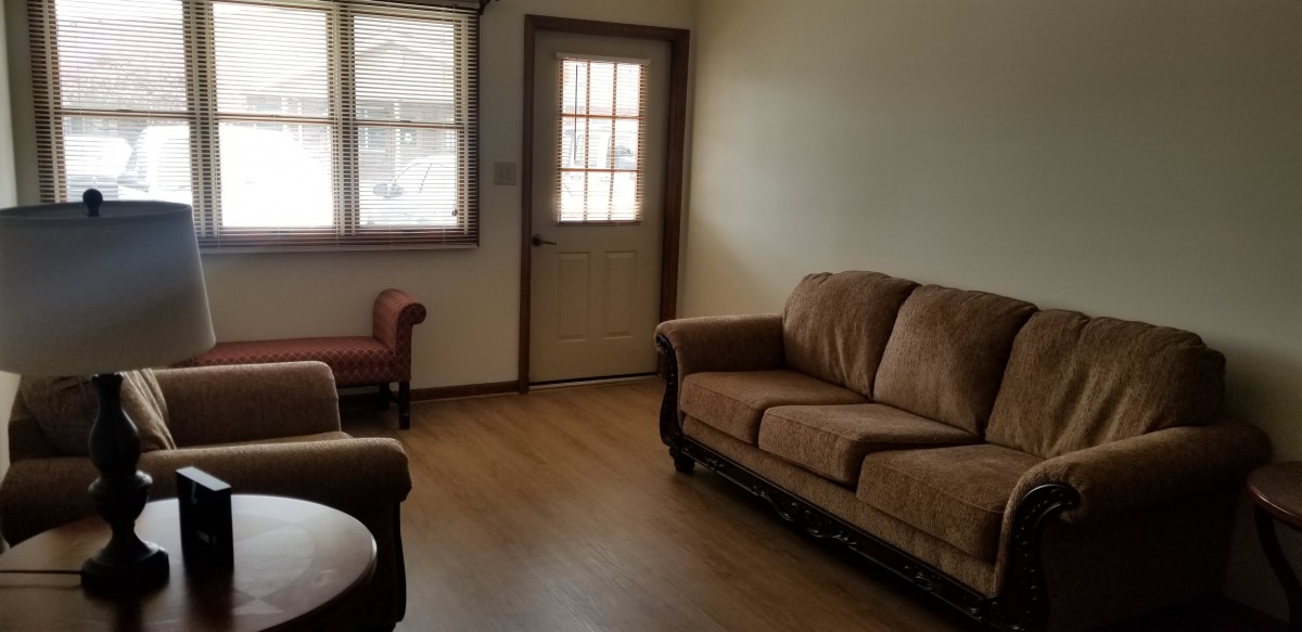 A cozy living room with a sofa and natural lighting.