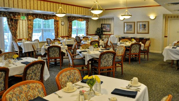 A formal dining room setup with neatly arranged tables and chairs, complete with elegant decorations.