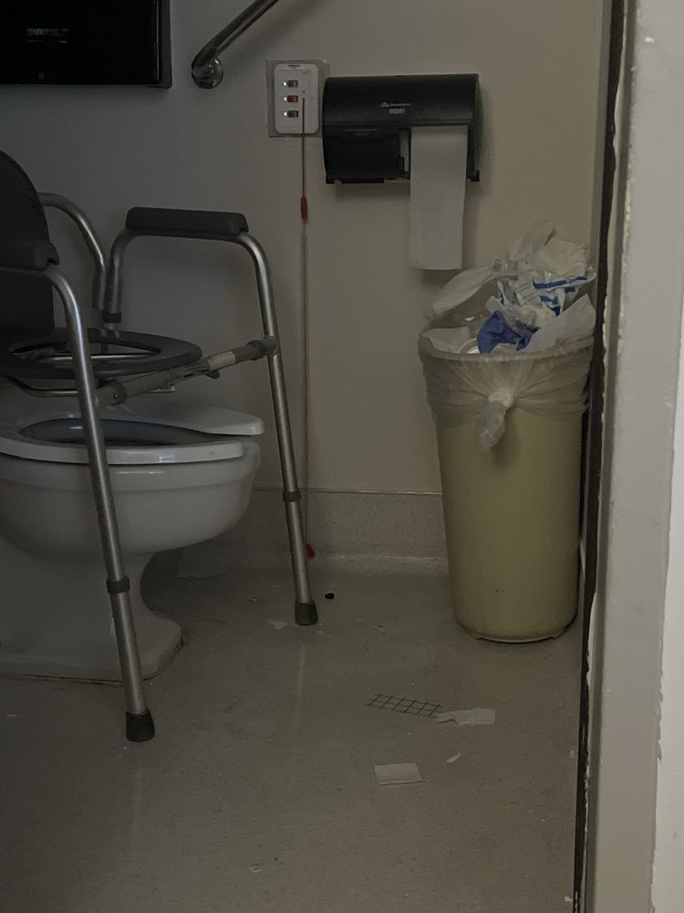An accessible bathroom with a toilet and trash can.