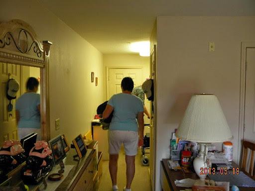 A person walking through a hallway in a home, surrounded by furniture and decor.