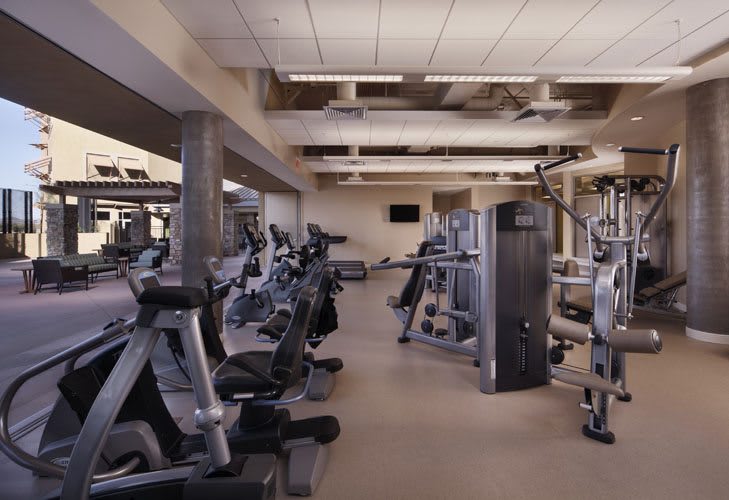 A modern gym filled with various exercise machines and equipment.