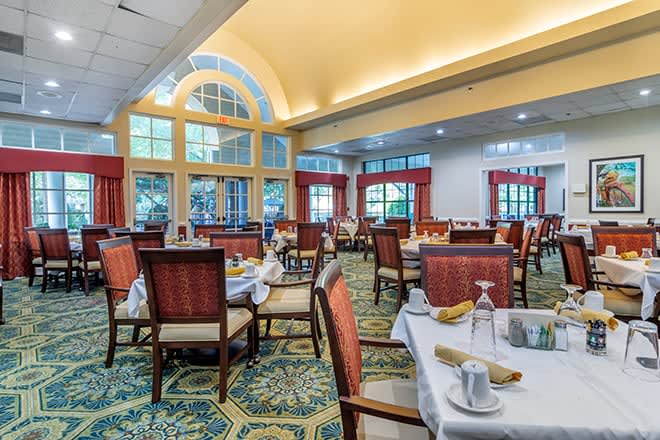 A spacious dining room with elegant decor and neatly set tables ready for guests.
