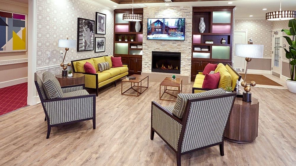 A modern living room with vibrant furnishings, a fireplace, and a television.