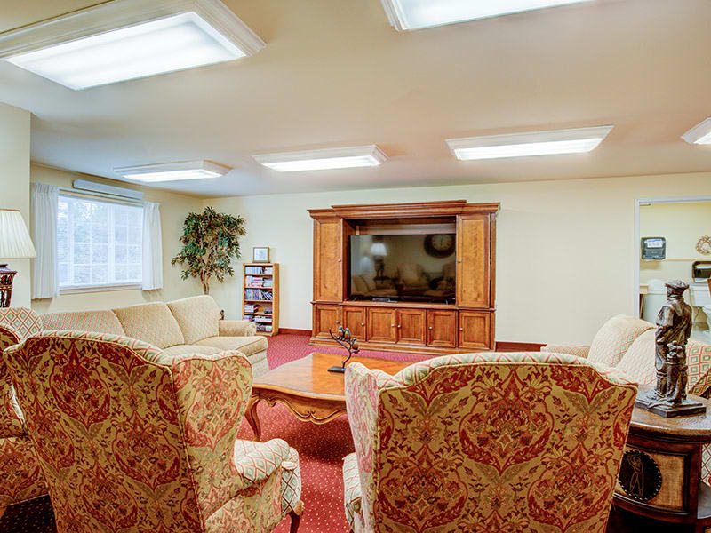 A cozy living room with comfortable seating, a large television, and warm lighting.