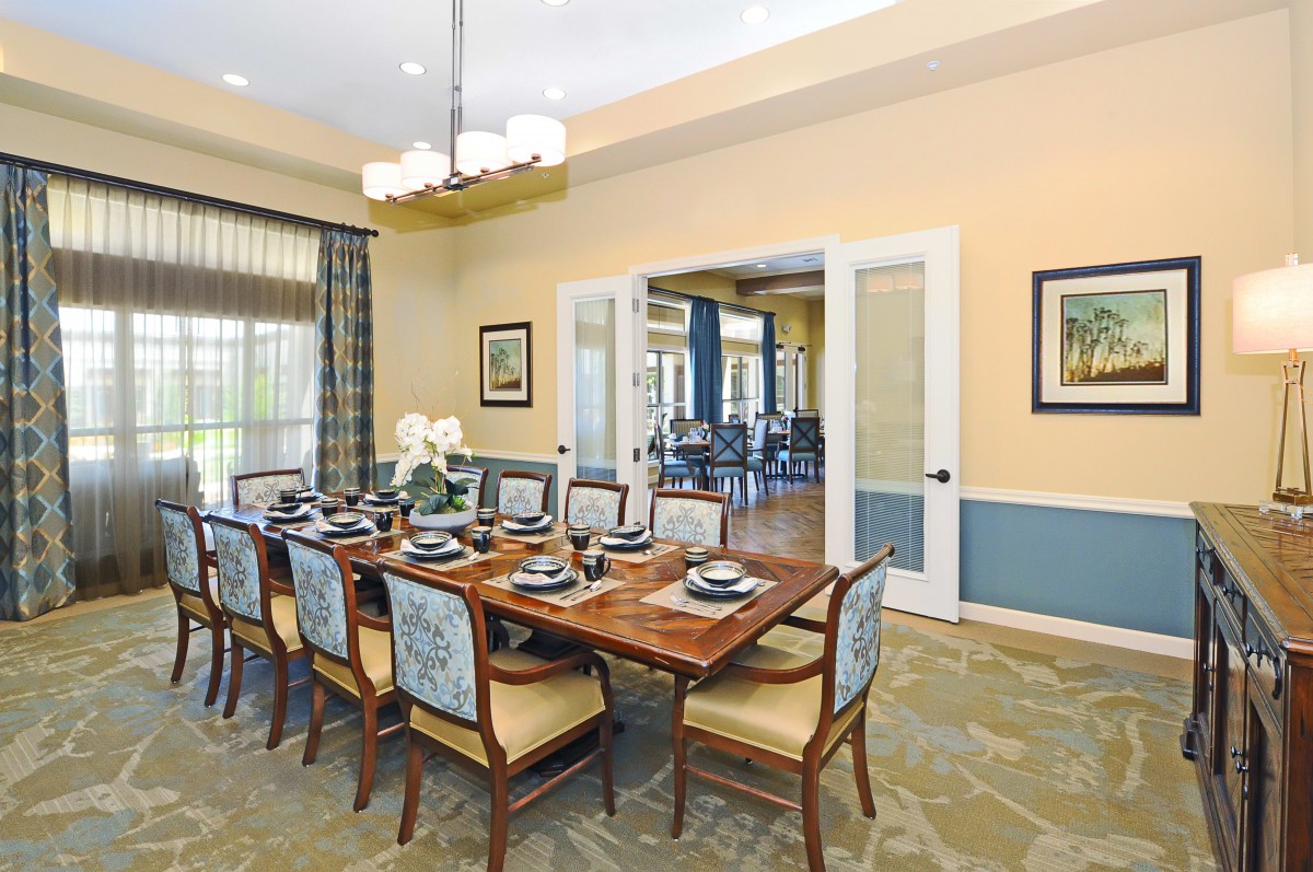 Elegantly designed dining room with a set table and chandelier.