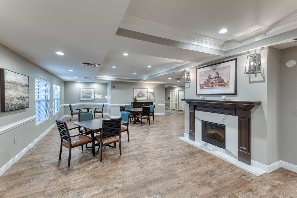 A cozy living room with seating area, dining table, and a fireplace.