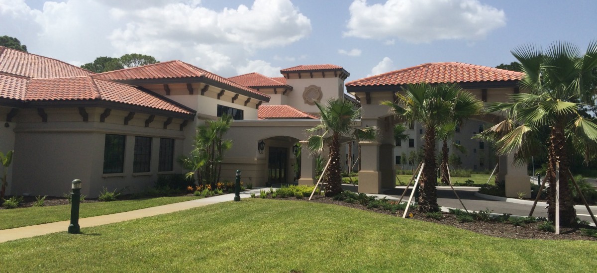 A large residential house with a red-tiled roof and landscaped garden.
