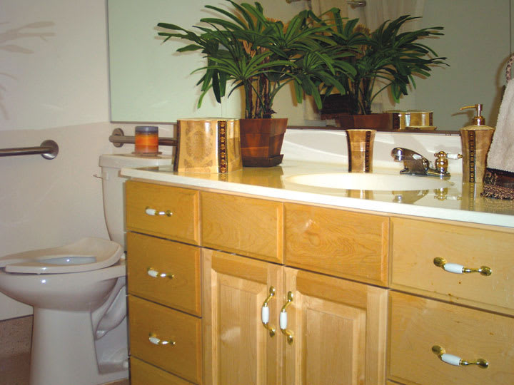 A well-kept bathroom with wooden cabinets and decorative plants.