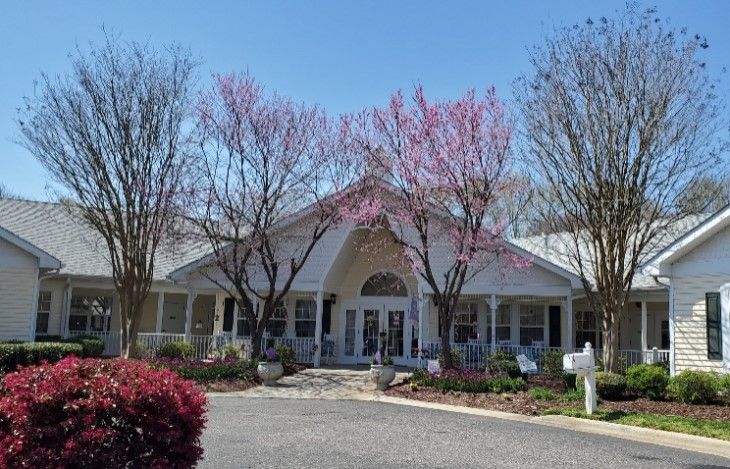 A charming building surrounded by blooming trees and spring foliage.