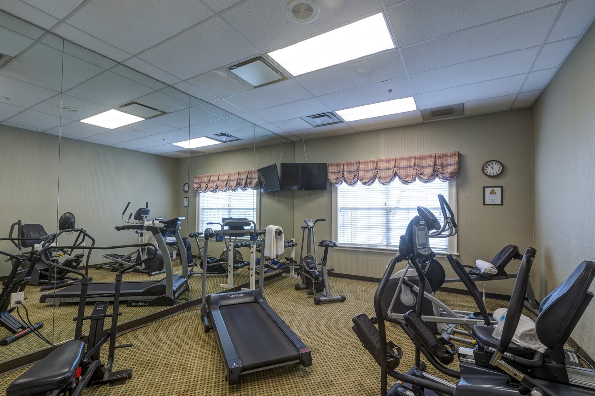 A small gym with exercise equipment, including treadmills and ellipticals.