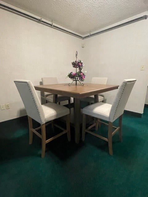 A cozy dining area with a wooden table and cushioned chairs, complemented by a decorative centerpiece.