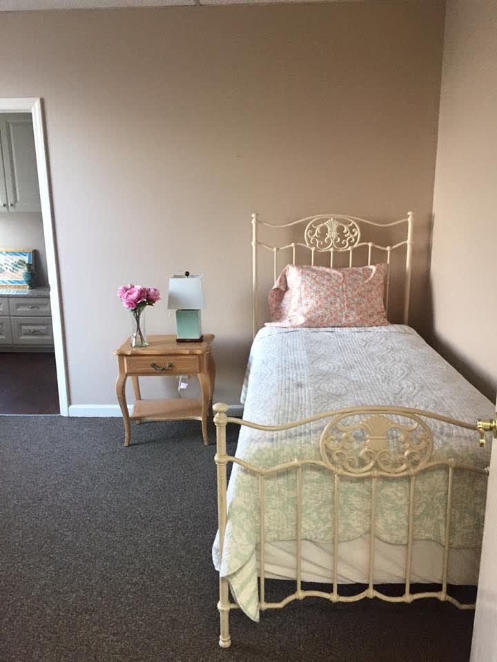 A quaint bedroom with a vintage single bed and a decorative nightstand.