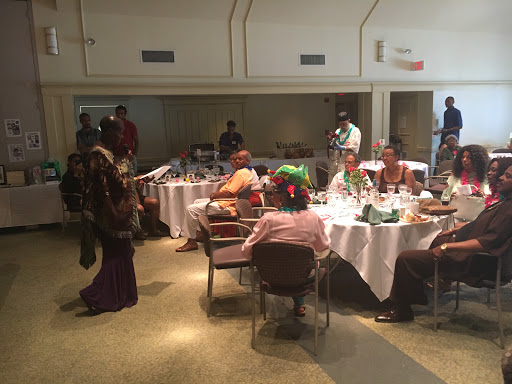 A lively gathering with guests enjoying a meal in a decorated dining space.