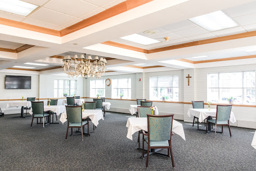 A well-lit dining area featuring elegantly set tables and a decorative chandelier.