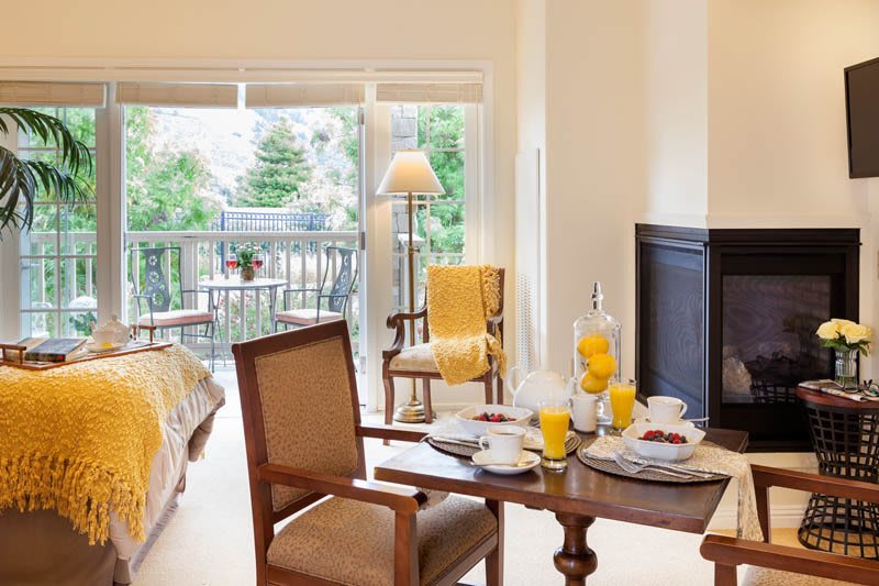 A cozy dining and living area with a breakfast setup and a view of the balcony.