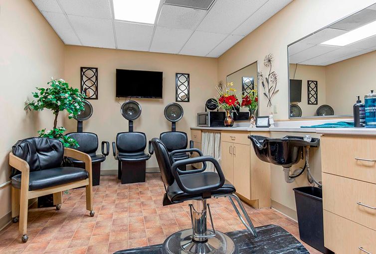Interior of a hair salon featuring styling chairs, mirrors, and hair dryers.