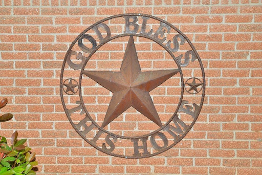 A decorative metal piece displaying the phrase 'God Bless This Home' framed by a star.