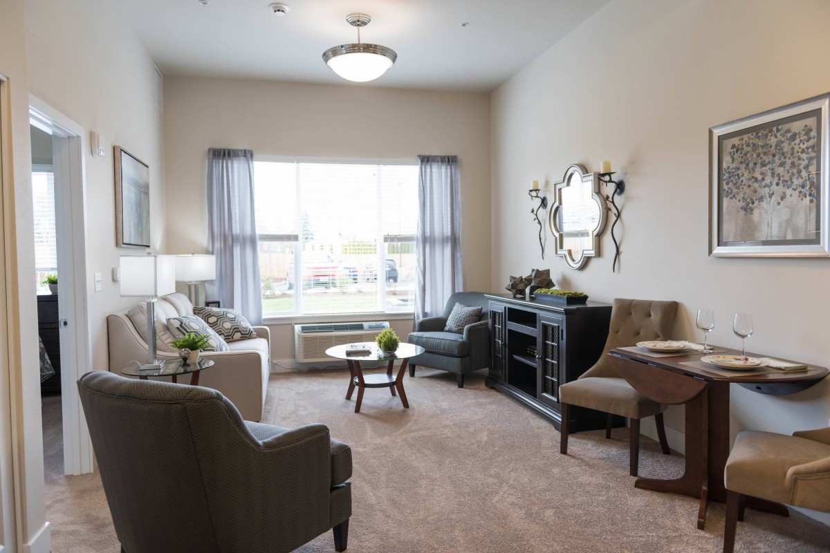 A cozy living room with stylish furniture and a large window allowing natural light to fill the space.