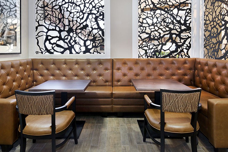 A modern restaurant interior with booth seating and abstract wall art.