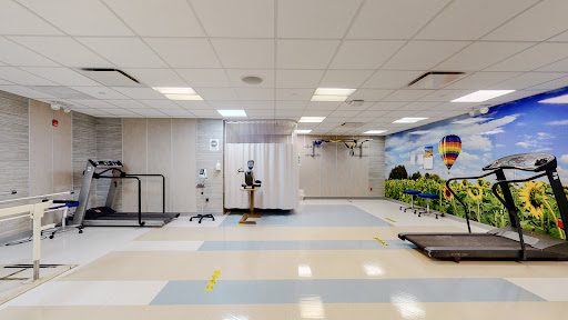 A spacious therapy room equipped with medical devices, designed for rehabilitation and physical therapy.