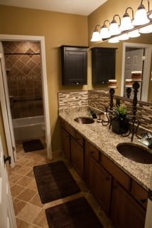 A well-designed bathroom featuring a double sink with granite countertops and decorative tiles.
