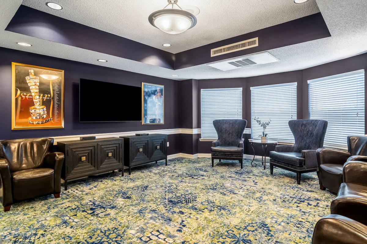 A modern lounge area with comfortable seating, a large television, and stylish decor.