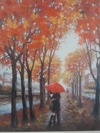 A serene autumn landscape featuring vibrant orange leaves and a figure holding a red umbrella along a peaceful pathway.