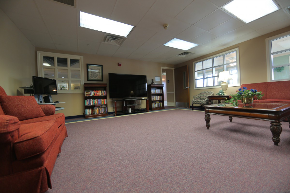 A cozy living room with a television, bookshelves, and comfortable seating.