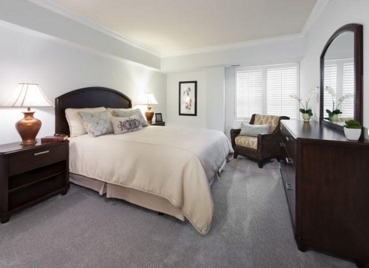 A cozy bedroom with a neatly made bed and elegant furnishings.