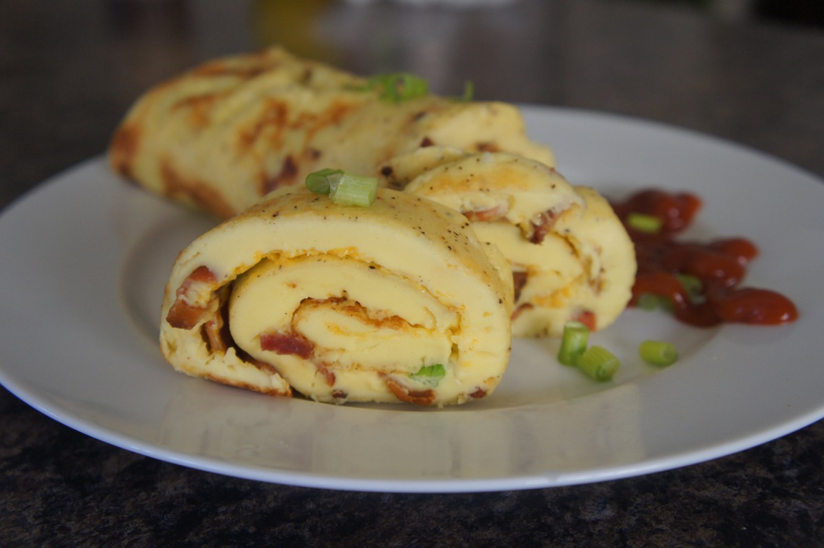 A savory omelette roll served on a plate, garnished with green onions.