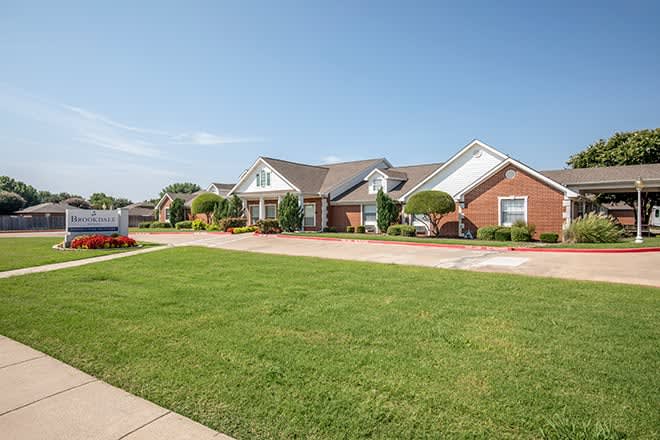 A suburban neighborhood with brick houses and well-maintained lawns.