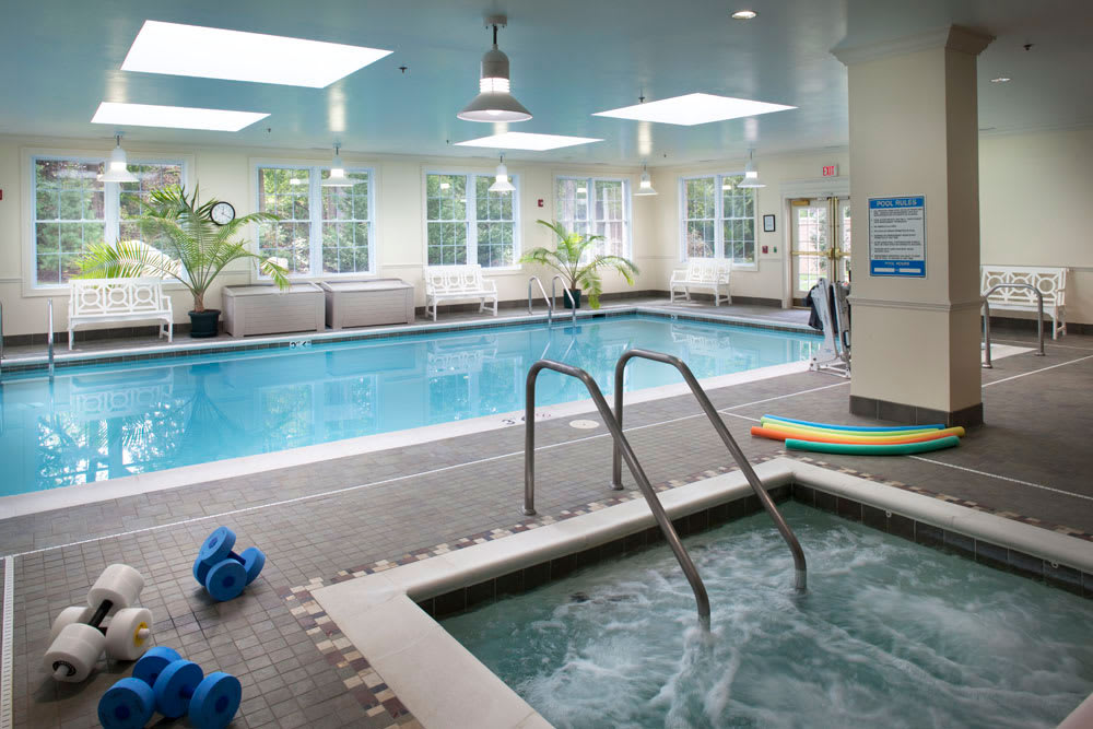 An indoor swimming pool and hot tub area with relaxation amenities.