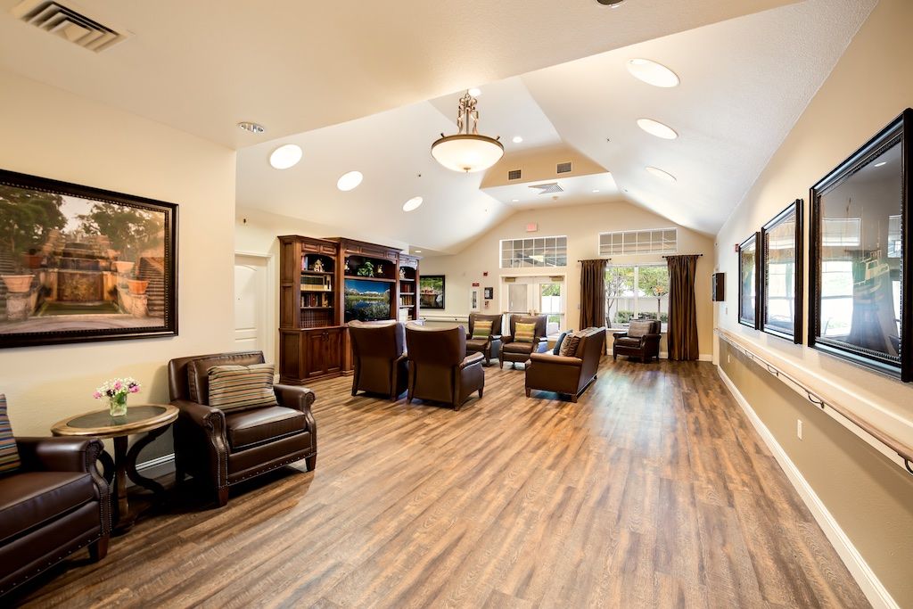 A spacious and cozy living room with hardwood floors, comfortable seating, and large windows.