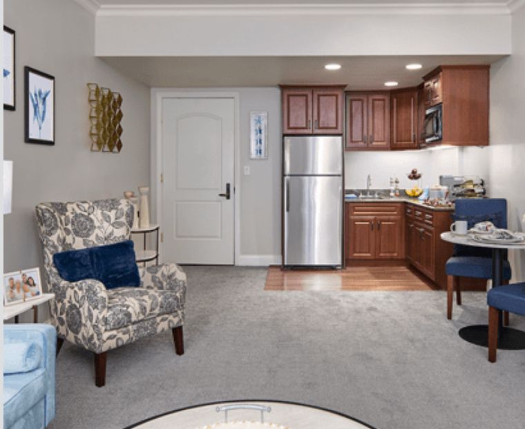 A cozy living space featuring a compact kitchen and a comfortable armchair.