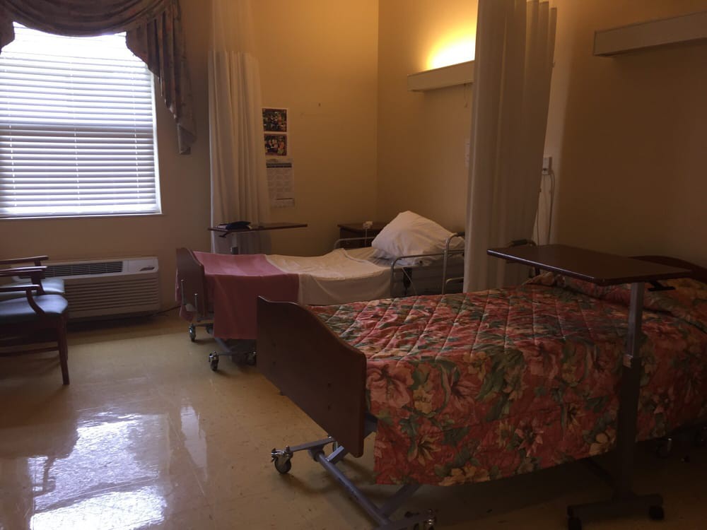 A quiet hospital room with two beds separated by curtains.