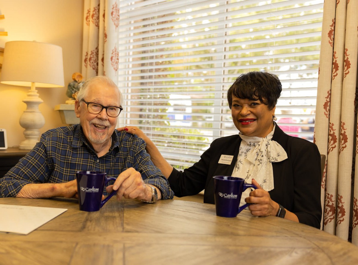 Two people enjoying a conversation over coffee at a table in a cozy setting.