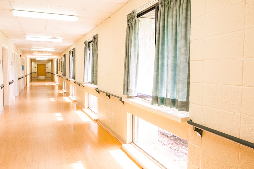 A bright and clean hallway with windows draped in curtains.