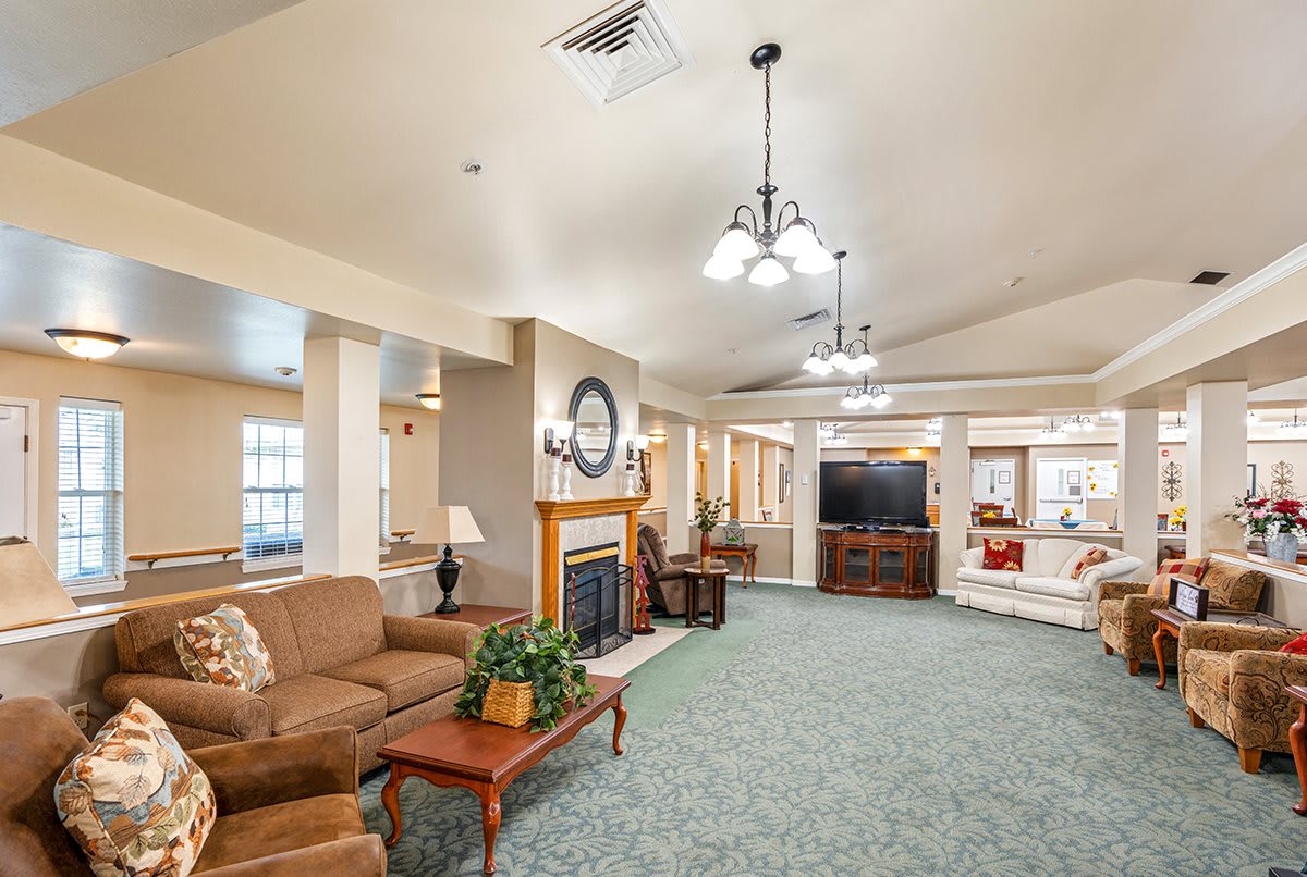A cozy living room with comfortable seating, a fireplace, and a large television.
