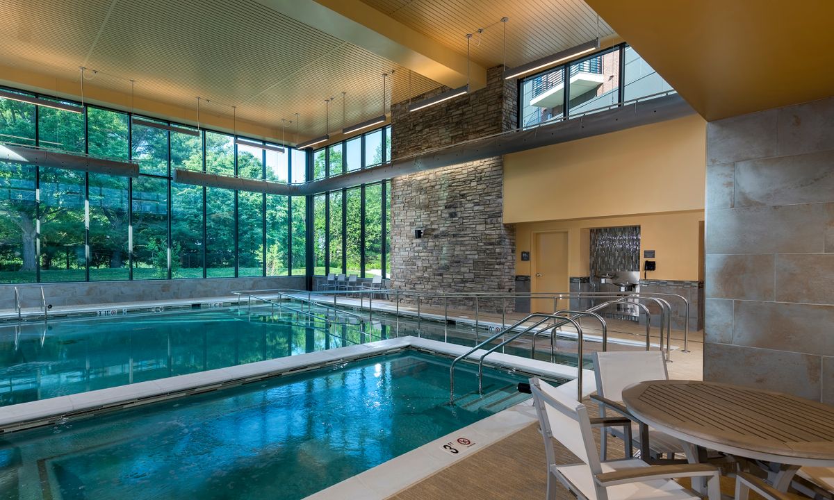 A modern indoor pool with large windows allowing natural light to fill the space.